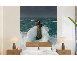 Behang - Fotobehang De vuurtoren van la Jument in Frankrijk voor een grijze lucht - Breedte 140 cm x hoogte 220 cm
