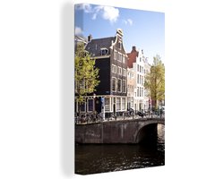 Canvas schilderij 120x180 cm - Wanddecoratie Grachtenpanden in Amsterdam naast een brug - Muurdecoratie woonkamer - Slaapkamer decoratie - Kamer accessoires - Schilderijen
