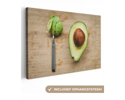 Canvas schilderij 150x100 cm - Wanddecoratie Avocado op een snijplankje met een lepel - Muurdecoratie woonkamer - Slaapkamer decoratie - Kamer accessoires - Schilderijen op canvas