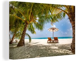 Canvas schilderij 150x100 cm - Wanddecoratie Ligbedden tussen de palmbomen op een strand van Bali - Muurdecoratie woonkamer - Slaapkamer decoratie - Kamer accessoires - Schilderijen