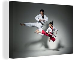 Canvas schilderij 150x100 cm - Wanddecoratie Twee mensen die taekwondo beoefenen - Muurdecoratie woonkamer - Slaapkamer decoratie - Kamer accessoires - Schilderijen
