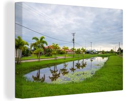 Canvas schilderij 180x120 cm - Wanddecoratie Water van een kanaal in Paramaribo, Suriname - Muurdecoratie woonkamer - Slaapkamer decoratie - Kamer accessoires - Schilderijen