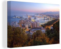 Canvas Schilderij Schemerige foto van Málaga skyline en verlichte Spaanse haven - 90x60 cm - Wanddecoratie