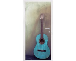 Deursticker Gekleurde akoestische gitaar in een kamer met een betonnen muur - 95x215 cm - Deurposter