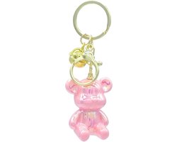 Een grappige en mooi parelmoer glanzende zittende beer 4,5cm aan een sleutelhanger waaraan een extra ring met kattenbelletje is bevestigd. Handig voor aan de sleutelbos, tas of op te hangen als decoratie. Voor uzelf of als cadeau.