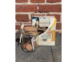 Kweekset glazen potje met zaden en houten lepel, kamille, thee