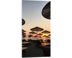 WallClassics - Acrylglas - Ligbedden met Rieten Parasols aan het Strand in de Avondzon - 50x100 cm Foto op Acrylglas (Wanddecoratie op Acrylaat)