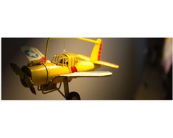 WallClassics - Poster Glanzend – Geel Kinderspeelgoed Vliegtuigje Zwevend in Kinderkamer - 90x30 cm Foto op Posterpapier met Glanzende Afwerking