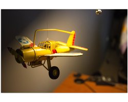 WallClassics - Poster Glanzend – Geel Kinderspeelgoed Vliegtuigje Zwevend in Kinderkamer - 90x60 cm Foto op Posterpapier met Glanzende Afwerking